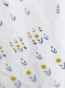 Close-up of minimalist 5D nail art stickers with yellow floral and purple leaf patterns
