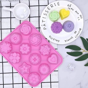 Pink silicone mold with 12 cavities for floral cake decorations and heart shapes