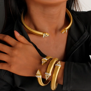 Close-up of golden spiral jewelry set with white rhinestones on model neck and wrist