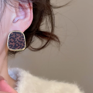 Gros plan de boucles d'oreilles carrées léopard avec bord doré sur l'oreille