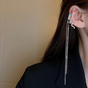 Détail du contour d'oreille serpent argenté avec gemmes vertes et longues chaînes