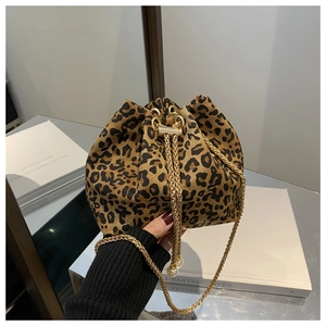 Detalle de bolso saco con estampado de leopardo, cadena dorada y cierre de cordón
