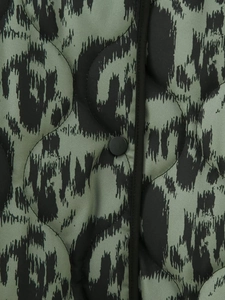 Close-up of quilted leopard print jacket with olive green pattern and black snap buttons