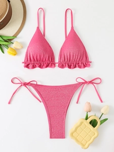 Bikini rose métallique avec volants et liens latéraux, vue à plat avec accessoires d'été