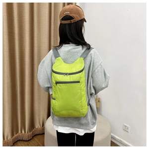 Lightweight foldable fluorescent green backpack shown on a model from the back view