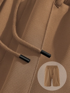 Close-up of brown waffle texture fabric with drawstring waist and product detail view