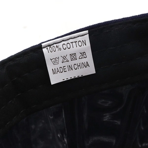 Detail view of the 100% cotton wash care label and stitching on a camouflage cap