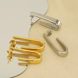 Boucles d'oreilles en acier inoxydable en forme de U or et argent sur miroir