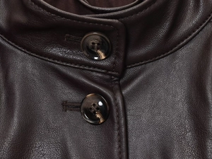 Detailed view of the dark brown leather jacket collar with amber patterned buttons