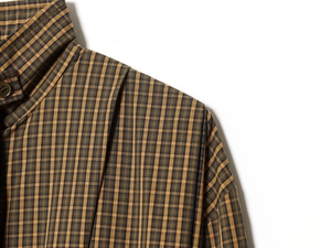 Detail view of the classic yellow and blue plaid pattern and button collar on a cotton shirt