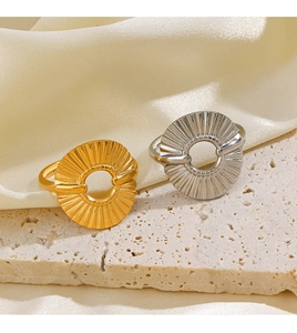 Detail of 18K gold and silver hollow round rings with pleated metal texture on silk