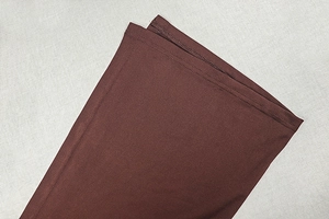 Vue macro détaillée de l'ourlet à double couture d'une mini robe moulante marron foncé