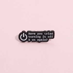 Détail macro de la broche émaillée avec texte Have you tried turning it off and on again