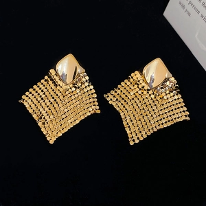 Detail view of golden rhombus mesh fringe earrings with intricate woven metallic textures