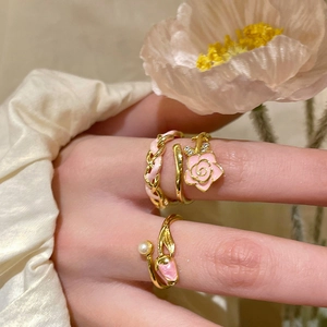 Detail of adjustable flower rings with pink enamel and pearl on a model finger