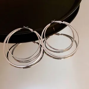 Boucles d'oreilles créoles triple épaisseur argentées au fini poli et aux reflets miroirs