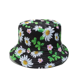 Détail du motif marguerites blanches et fleurs roses sur un chapeau bob noir