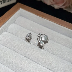 Detailed close-up of a silver bow ring with rectangular zircon in a velvet jewelry box