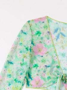 Detail of floral chiffon swimsuit cover-up with V-neck and bright green hem stitching