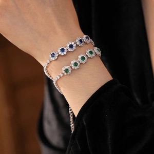 Bracelets fleurs vintage en zircon bleu et vert portés sur un poignet délicat