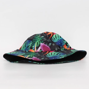 Close-up of tropical leaf and floral print on a black outdoor sun protection bucket hat
