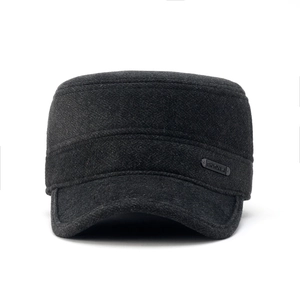 Close-up of flat top wool hat with side metal logo plate and warm felt material