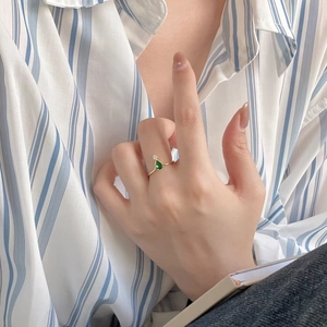 Minimalist 925 sterling silver ring with pear-shaped green gemstone on a model's hand