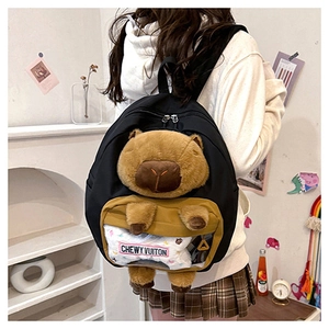 Detail of Capybara plush backpack featuring transparent pocket with Chewy Vuitton bone charm