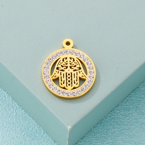 Hamsa hand pendant in gold finish with sparkling zircons on a blue geometric background