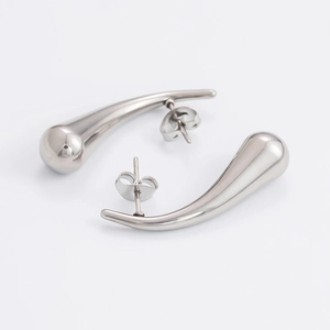 Macro view of silver teardrop stud earrings with polished hollow metal finish