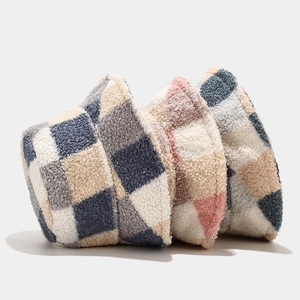 Three lamb wool checkerboard bucket hats in gray, pink, and blue showing soft texture