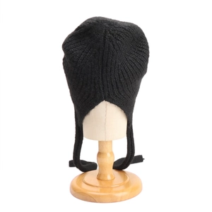 Dettaglio del cappello in maglia a coste nere in misto lana con paraorecchie lunghi