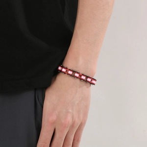 Detail shot of a stylish bike chain bracelet in red black and pink colors on a male wrist