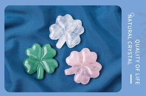 Detailed close-up of natural crystal four-leaf clover carvings in pink, green, and white