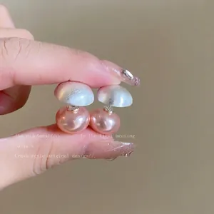 Detail view of pearl earrings with brushed silver sphere and purple pearl finish