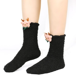 Detail von flauschigen schwarzen Korallenfleece-Socken mit süßer 3D-Rentierpuppe