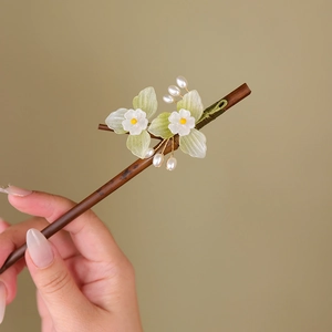 Detail of wooden hair stick with green faux jade flowers and white pearls for hanfu