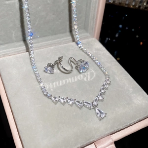 Macro detail of silver drop pendant necklace and sparkling zircon ring in a gift box