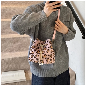 Detail of pink leopard plush bucket bag with golden chain drawstring and pearl accents