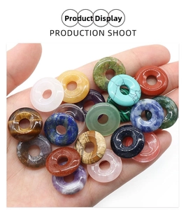 Macro view of assorted 18mm natural crystal donuts held in hand for jewelry making
