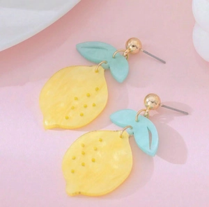 Close-up of yellow acrylic lemon earrings with light blue leaves and golden stud hooks