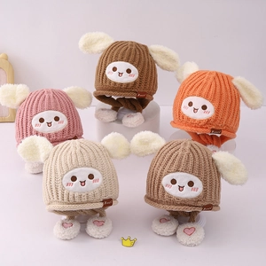 Détail de bonnets tricotés pour enfants avec longues oreilles de lapin et pompons