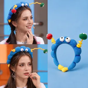 Blue plush headband with cute alien eyes and colorful antennas as seen on celebrities