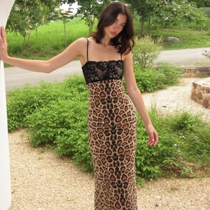 Detail of leopard print maxi dress featuring black lace trim and slender straps