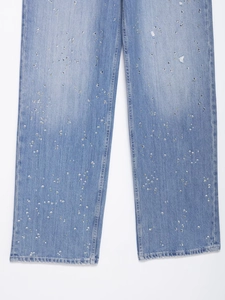 Gros plan d'un jean bleu clair orné de strass et de détails usés de haute qualité