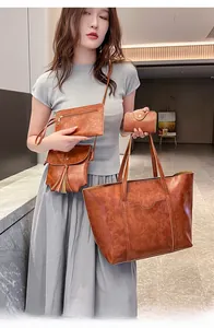 Close-up of four-piece vintage brown oil wax leather bag set including tote and crossbody