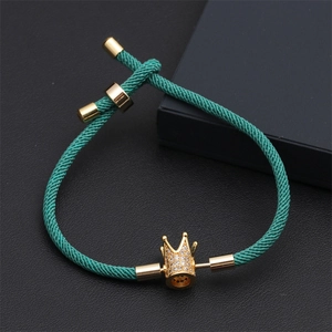 Gros plan détaillé du bracelet couronne tressé vert foncé sur fond en cuir noir