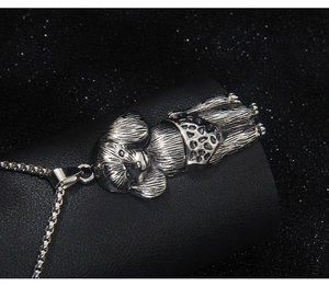 Detailed close-up of a silver retro poodle pendant with a vintage textured finish