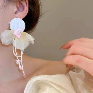 Close-up of chiffon flower petal earrings with pearl tassels on model's ear