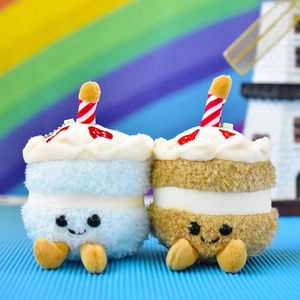 Detailed view of two cute blue and brown mini cake plush keychain dolls with candles